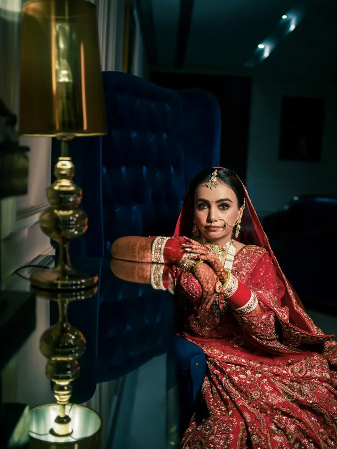 Wedding Shedding - Classic Bride Portrait in Red Lehenga by Royal Blue Armchair