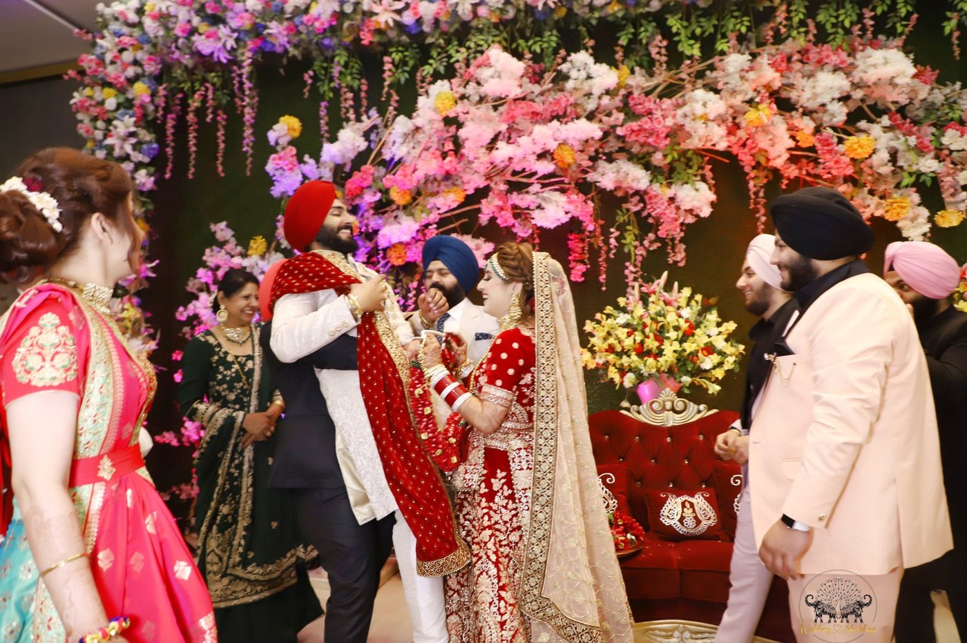 Joyful wedding varmala stage celebration with golden floral backdrop by Wedding Shedding