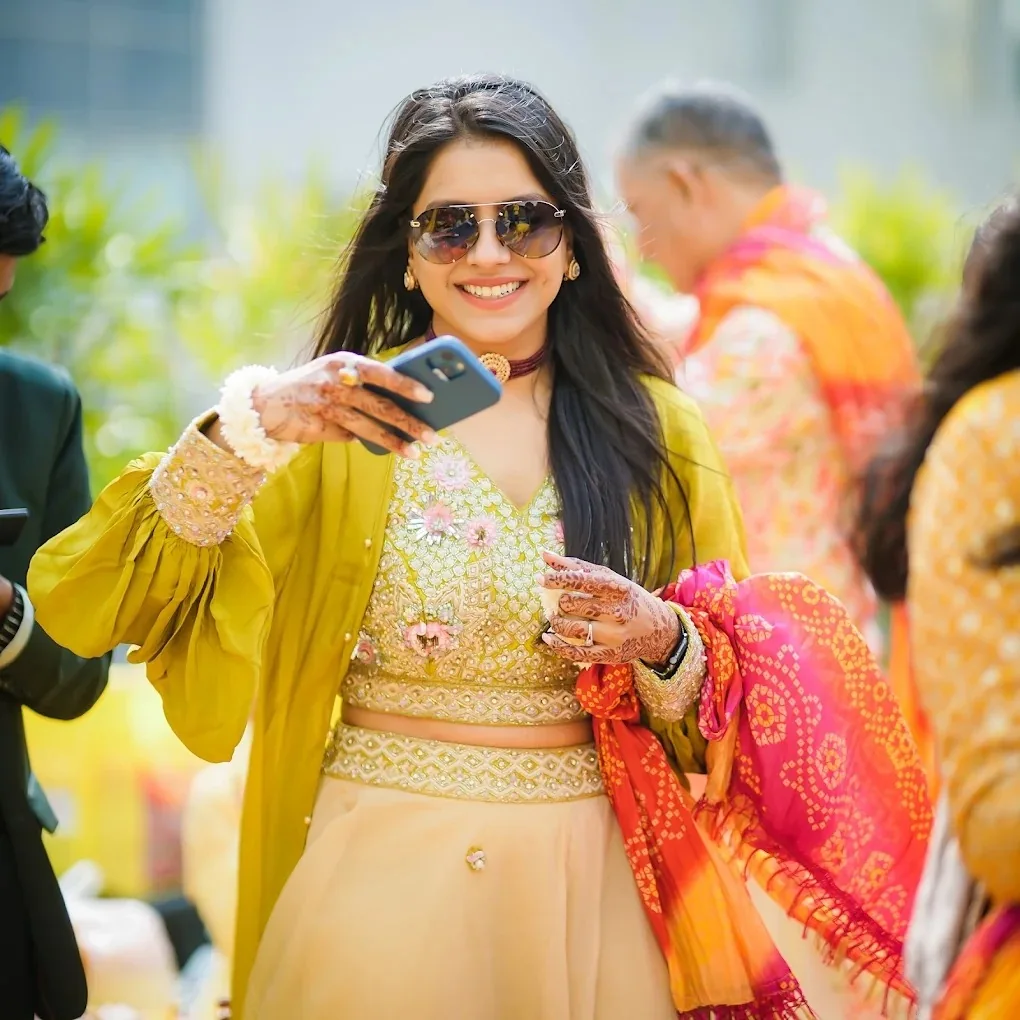Chic guest in modern ethnic wear and sunglasses celebrating at mehendi