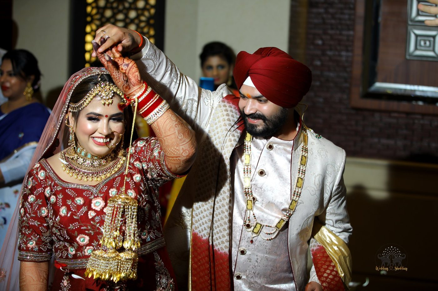 Groom and bride dancing joyfully with golden kaleere