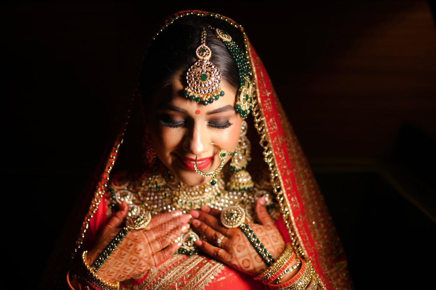 Regal bride in sacred red veil and polki heirloom jewelry